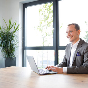 Ein gut gekleideter Mitarbeiter in einem der hellen Aufenthaltsräume der FRISTO Unternehmenszentrale in Buchloe.