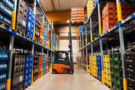 Ein Stapler hebt in unserem FRISTO Logistikzentrum eine Getränkepalette an, um diese für den Transport fertig zu machen.