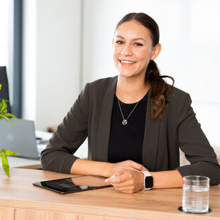Eine schick gekleidete Mitarbeiterin im Büro, mit einem Tablet. Die moderne und helle Einrichtung der FRISTO Zentrale schafft Wohlfühlcharakter.