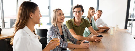 Unsere Mitarbeiter/innen unterhalten sich gut gelaunt im Aufenthaltsraum der neuen Fristo Unternehmenszentrale.